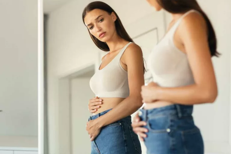 donna si specchia e vuole eliminare la pancia gonfia