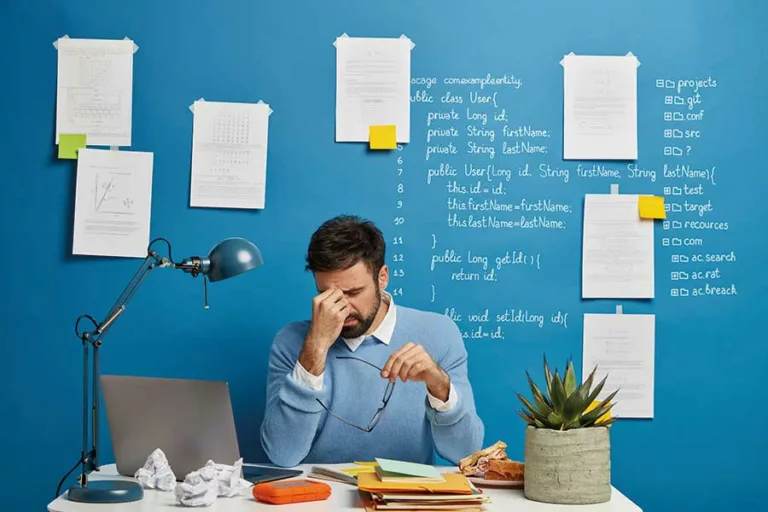 uomo stressato tiene la testa tra le mani