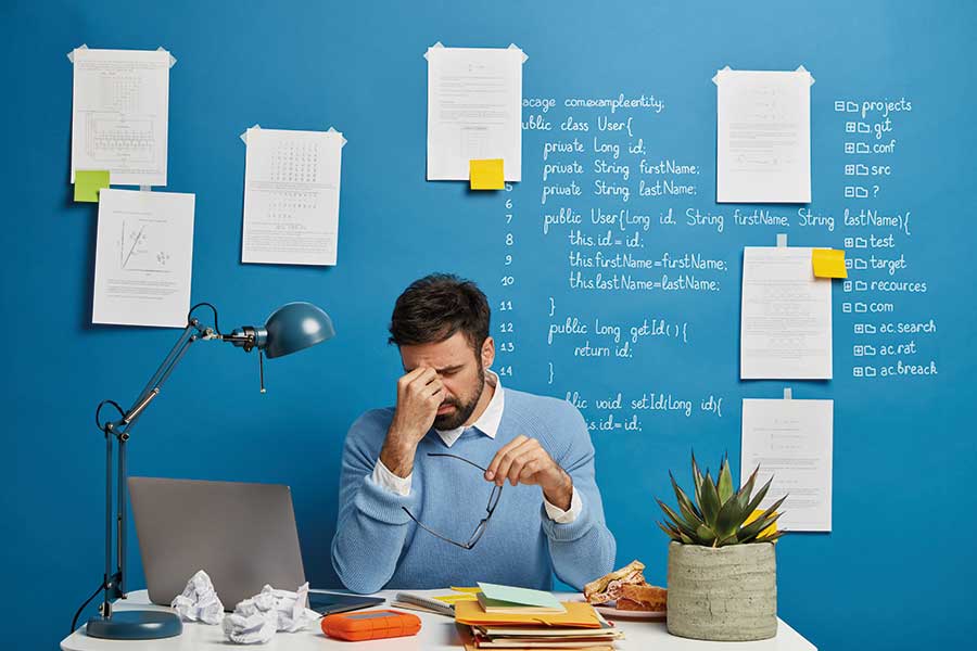 uomo stressato tiene la testa tra le mani